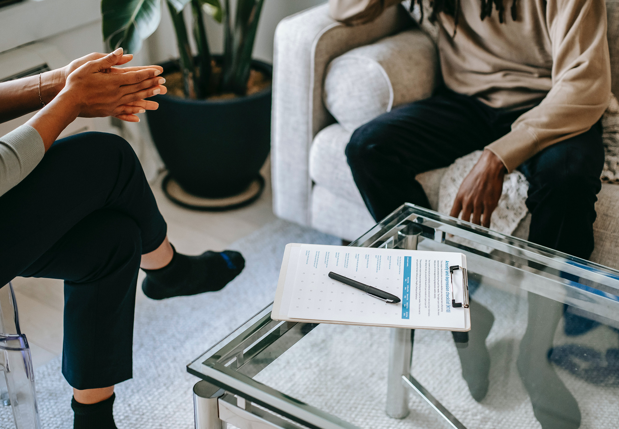 female psychologist talking to male patient, clipboard on the table